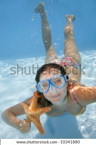 Pretty girl underwater with mask and starfish