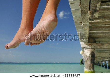 One of a large series. Great set of legs hanging over the edge of a tropical jetty.