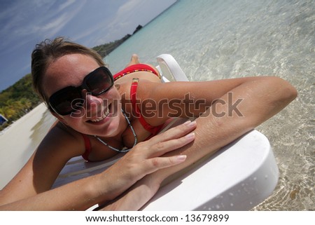 Pretty woman lying on the beach with a big smile