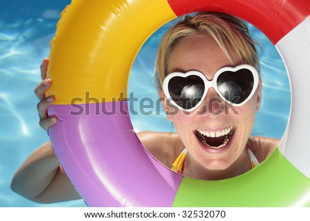 Laughing woman with sunglasses and inflatable toy
