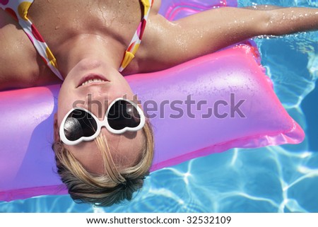 Laughing woman with sunglasses and inflatable toy