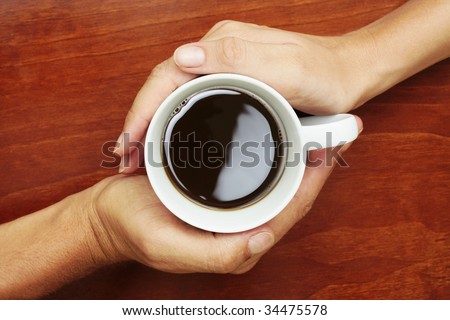 Coffee Cup betwen two hands in a yin and yang manner