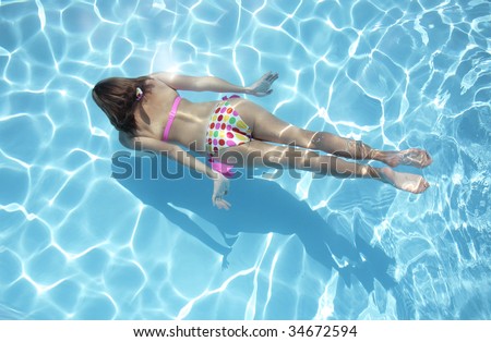 Woman in a polka dot bikini swimming underwater