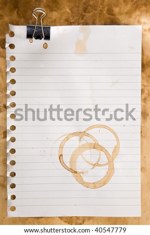 Paper from a notepad with coffee stains and clip