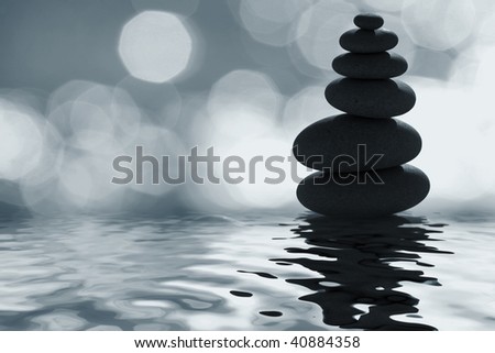 Stack of zen pebbles in the moonlight with defocused background highlights