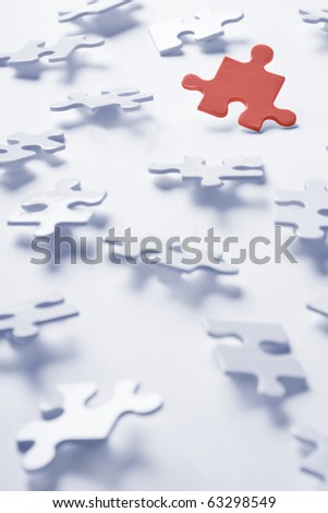 Jigsaw puzzle pieces on a white background with one red piece