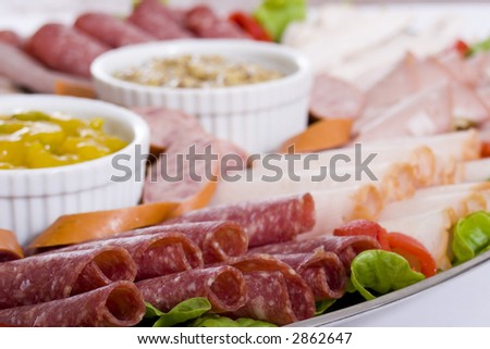 Cold meat catering platter with sliced chicken breast, mortadella, salami, roast beef, ham, turkey, kabana sausage and seeded wholegrain mustard and sweet mustard pickle.