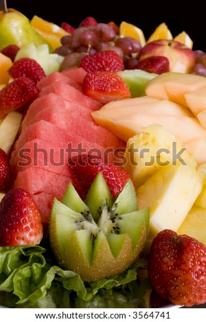 Assorted fresh seasonal fruits cut and arranged on platter