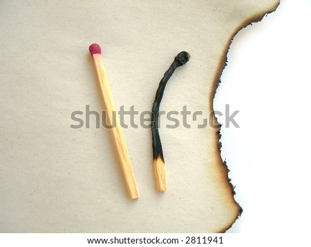 Two matches - whole and burnt one on burnt paper