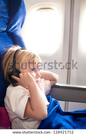 small child with headphones in the plane
