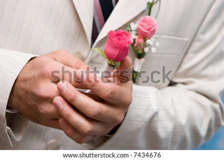 Man holds in hands a small bouquet from red roses