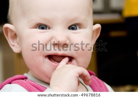child with finger in the mouth finding teeth