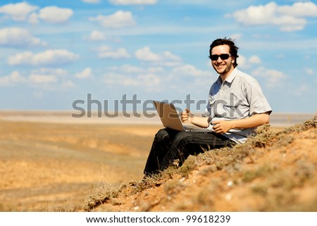 happy man with laptop on the hill