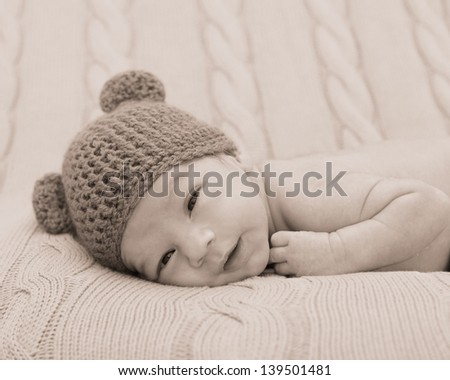 Newborn infant baby in cute knitted bear hat