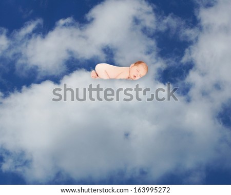 Newborn baby in natural sleeping pose floating on a cloud in blue sky