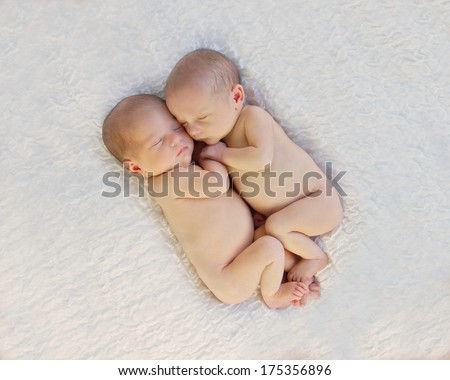 Sleeping Newborn Baby Twins, Snuggled Up Together In Loving Embrace, Holding Hands