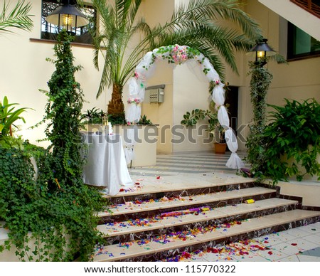 Rose petals line the bridal path leading to the wedding arch