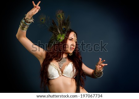 Performance. Young attractive retro model in old-fashioned wild clothing dancing. Tribe. Tattoo. Native savage woman