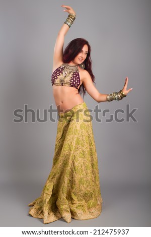 Beautiful girl belly dance movement, Young beautiful belly dancer in a  golden costume