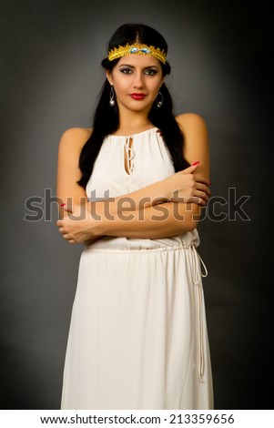 beautiful young brunette woman in a bright dress on a gray background