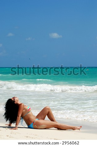beautiful brunette tanning at white sandy beach