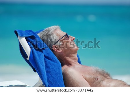 Old man tanning by the caribbean ocean