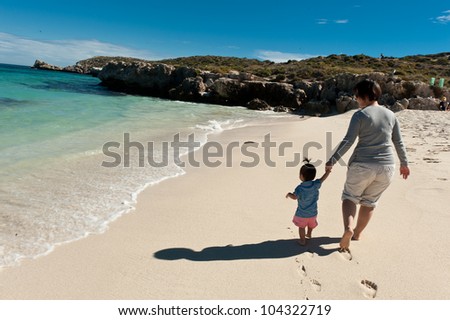 Mother and daughter walking on the beach