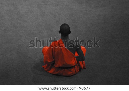 Buddhist monk sitting down in meditation pose