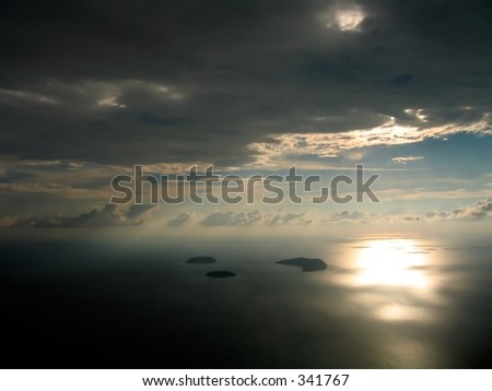 Sunlight breaking out from the clouds, casting a bright reflection over the ocean