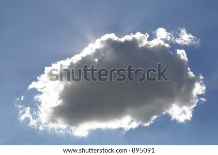 Cumulus cloud with a silver lining on an afternoon sky, with the sun shining in the background