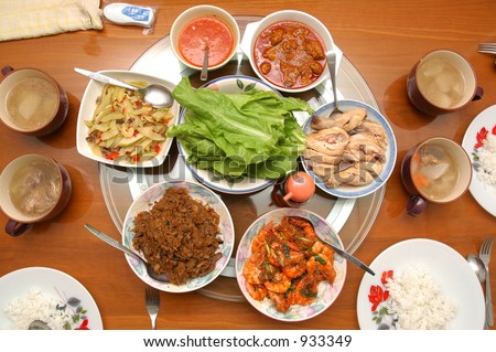 Asian food laid out for dinner on a wooden table, served for Chinese New Year reunion dinner celebrations