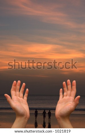 Hands reaching to heaven, on a cloud-filled orange sunset sky background, with 3 men walking on a beach