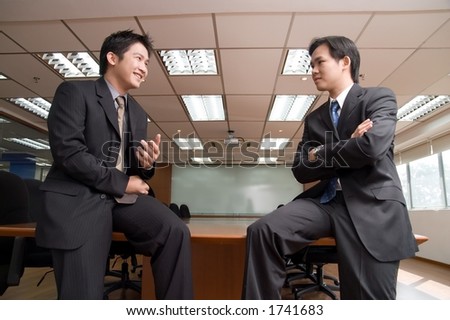 Asian men in business attire in front of conference room