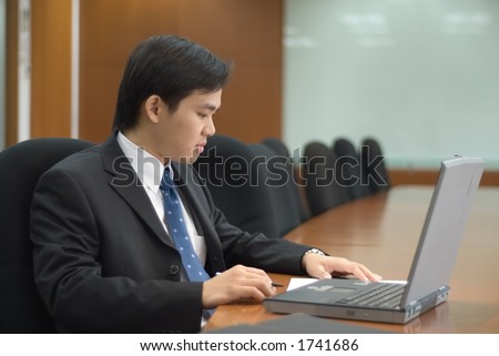 Asian man in business attire working on notebook pc