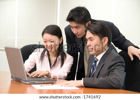Asian business people in business attire working on a notebook pc