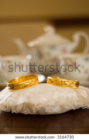 stock photo Pair of golden wedding rings sitting on pillow for Chinese 