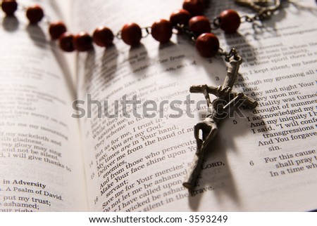 Red rosary and holy bible, shot with dramatic lighting