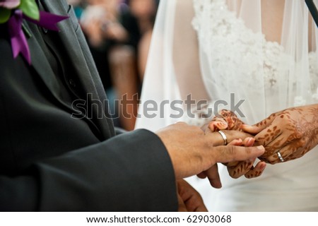 Bride putting wedding ring on groom\'s finger