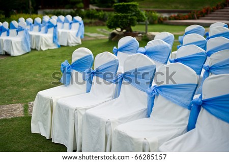stock photo Seats with blue sashes at an outdoor garden wedding ceremony