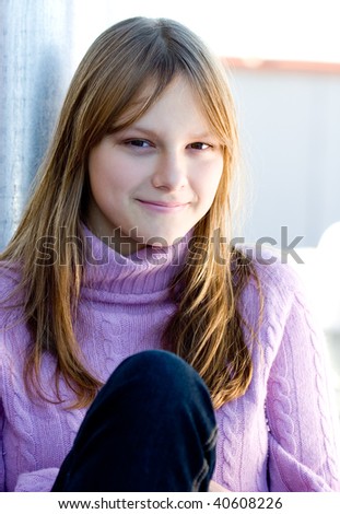 Portrait of a beautiful happy smiling young teenage girl with blond hair and bang