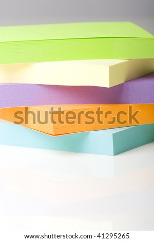 Close up of a pack of colorful green, yellow, purple, orange, blue post it notes