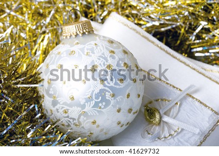 Decoration Christmas New Year silver ornament ball on a shiny golden background with fabric napkin close up