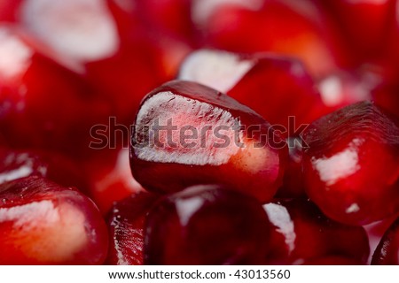 Extreme close up background of a red juicy ripe pomegranate fruit seeds