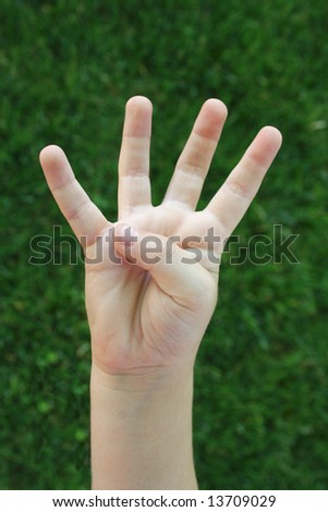 A child\'s hand holding up four fingers demonstrating the number four