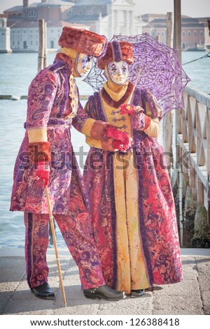 VENICE,ITALY-FEB.17 : Couple of unrecognizable person wearing carnival costume and posing along Saint Mark waterfront on February 17, 2012 in Venice, Italy.  2012 Carnival was between 11-21 Feb.