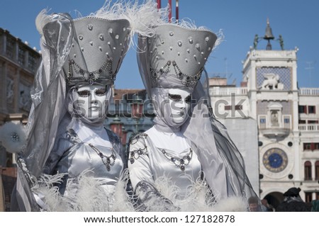 VENICE,ITALY-MARCH 4 : Unrecognizable couple wearing similar carnival costumes and posing in Saint Mark square on March 4, 2011 in Venice, Italy. In 2011 the Carnival was held between 3-11 March.