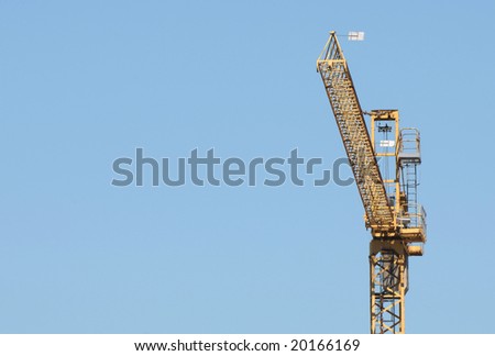 High section of a building crane over blue sky (space on left)