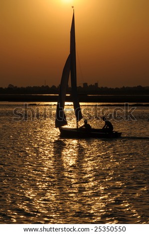 Silhouette of a cruising sailing boat at sunset