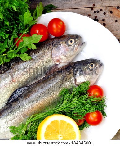 Two trout on a plate with vegetables