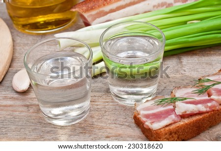 glass of vodka, onions and bacon sandwich